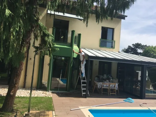 Véranda, auvent et boiseries au bord d’une piscine, travaux en cours