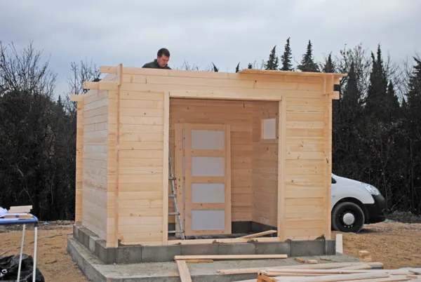 Abri en bois fini, avec ses portes et ses fenêtres