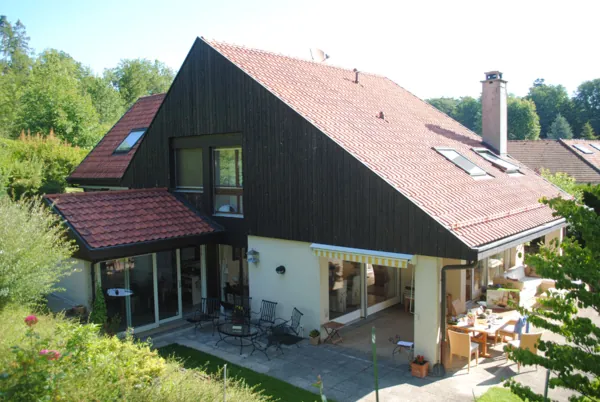 Chalet au bardage foncé, lasure appliquée