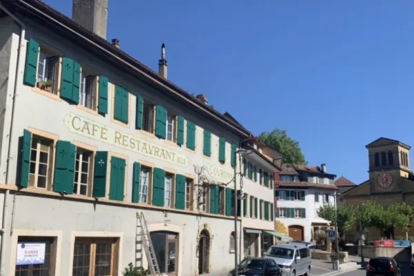 Ancien café-restaurant, fenêtres sans leurs volets, une échelle contre le mur