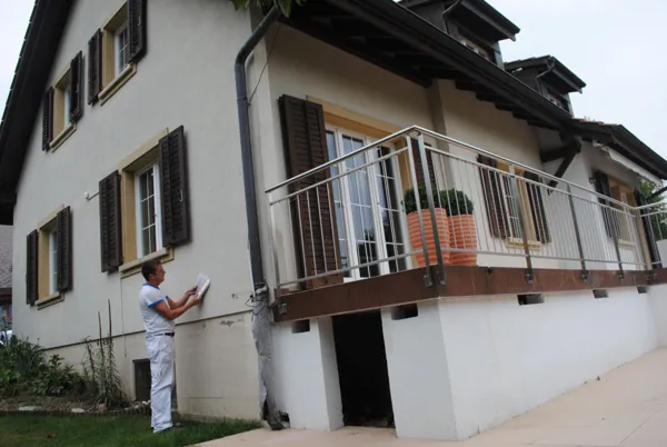 Balcon et encadrements repeints sur une façade claire