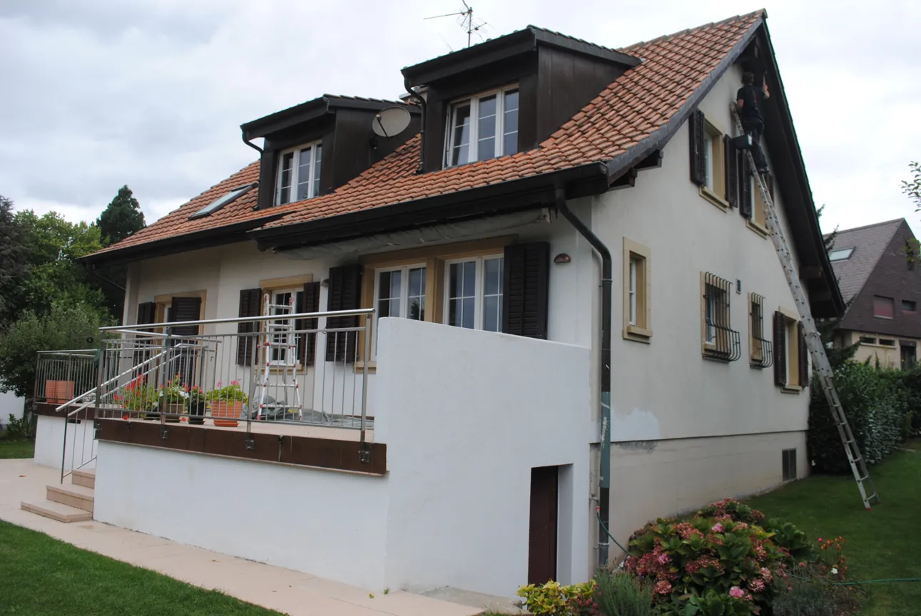 Façade d’une maison fraîchement repeinte, photographiée depuis le jardin