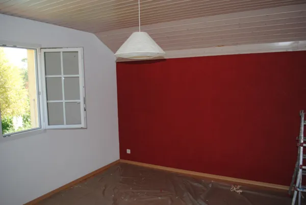 Mur rouge profond, suspension blanche, pièce lumineuse