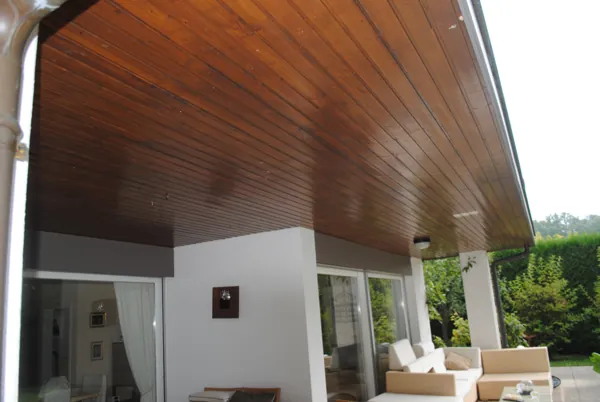 Véranda vitrée au plafond en bois fraîchement traité