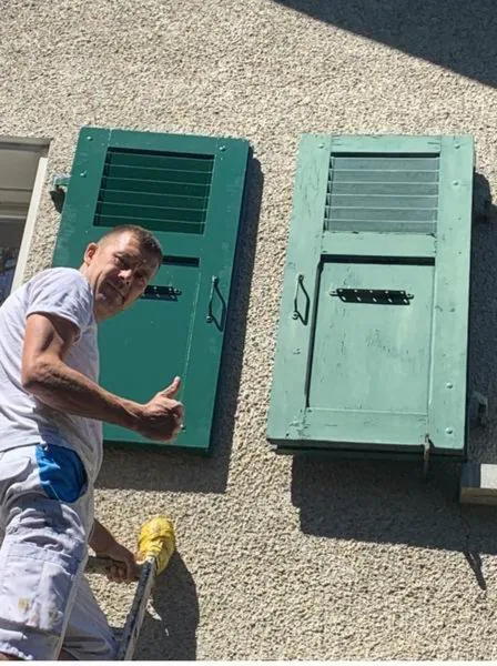 Paire de volets verts restaurés, en train de sécher au sol